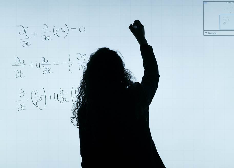 Silhouette of woman writing equations